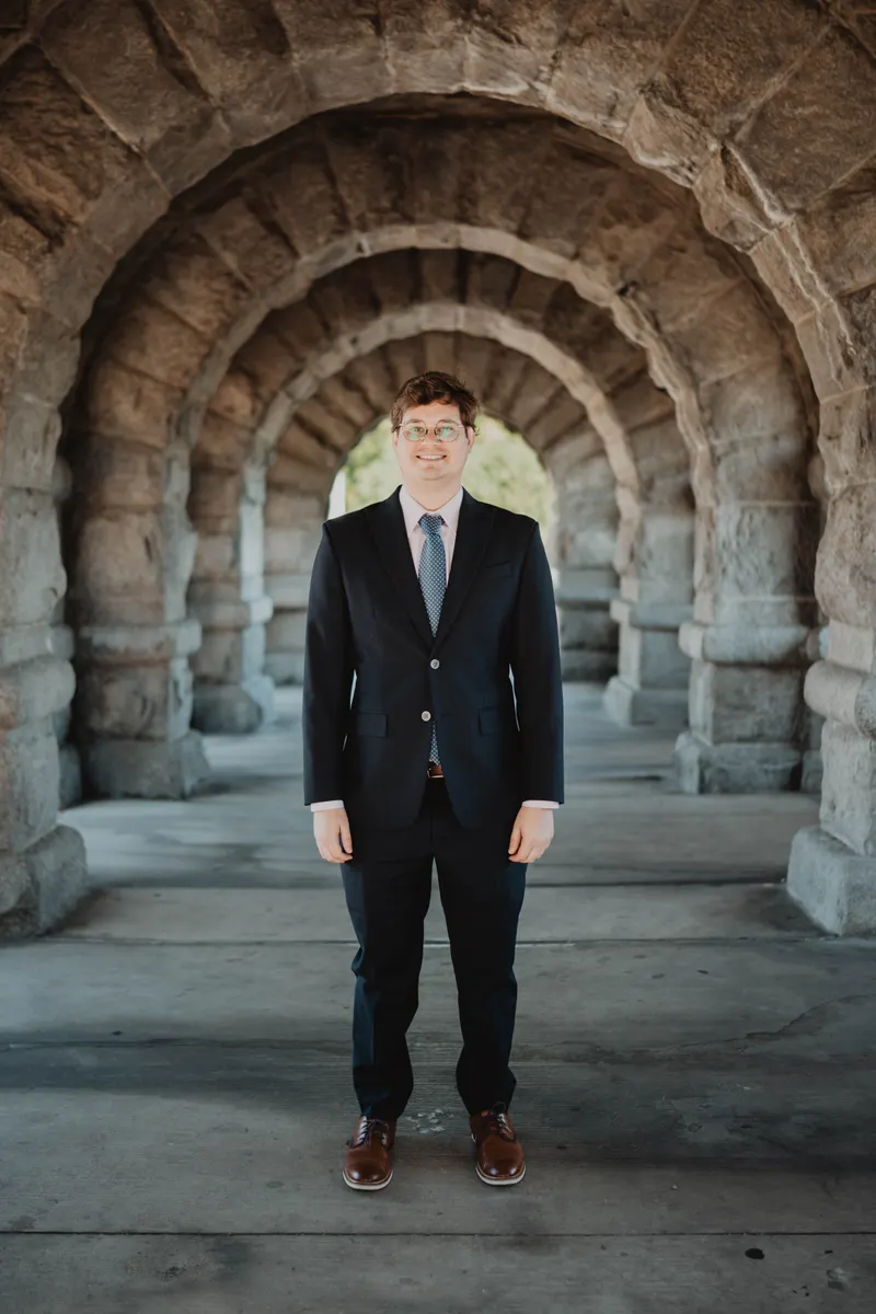 Riley Silber standing beneath a row of stone arches in Chicago